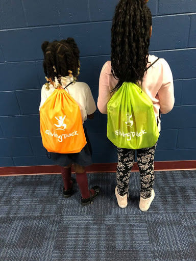 2 young Bradford students showing off their new backpacks - "Giving Pack"