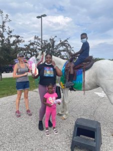 Students riding a horse at our back to school bash